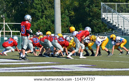 CUMMING, GA/USA - SEPTEMBER 22: Unidentified players at the line during a football game of 7th grade boys September 22, 2012 in Cumming GA.  North Forsyth vs Lakeside.