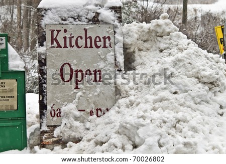 Get a paper and come on in out of the snow if you can.  Sign in front of a small store during a winter storm.