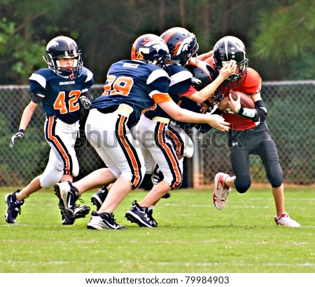 CUMMING, GA - SEPTEMBER 12: Unidentified players make a tackle during a Broncos vs.The Eagles recreational football game on September 12, 2009 in Forsyth County, Cumming, GA. The game is part of the local Recreation Department Football Program.