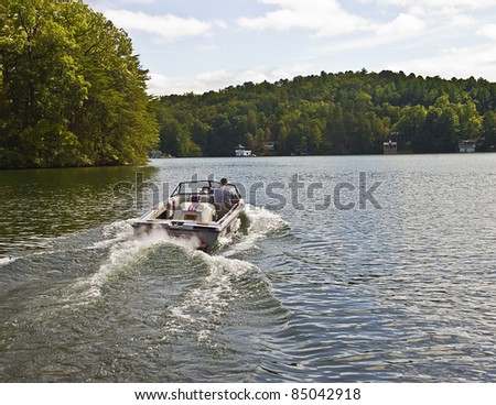 Man driving a ski boat in a lake.