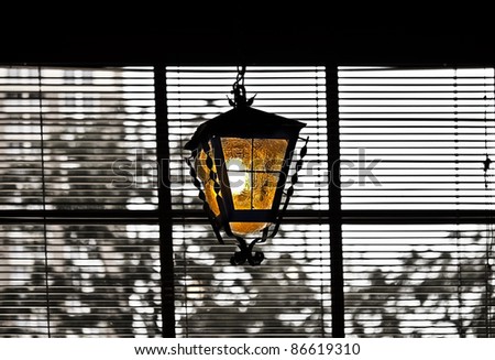 A colorful glass lantern hanging in a window.