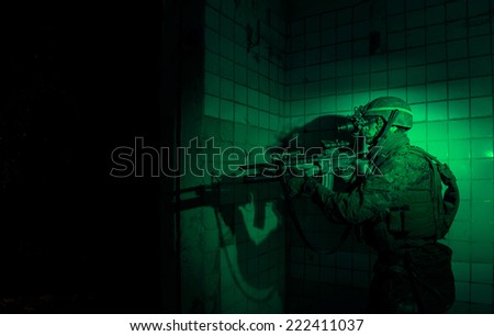 US Marine captures enemy military facility, using a night vision device.