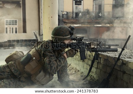 American soldier on the battlefield in an attack/defensive position. Soldier lying in the shelter.