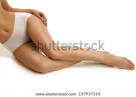Closeup of a girl lying on the floor showing beautiful legs on white Closeup of a girl lying on the floor showing beautiful legs on white