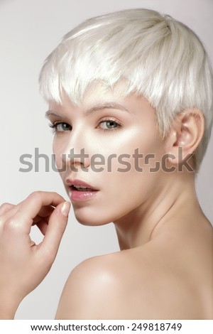 Beauty model blonde short hair showing perfect skin  on white