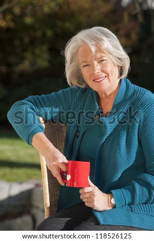 Elderly woman relaxing on the patio with coffee