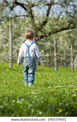 Little boy walks from behind
