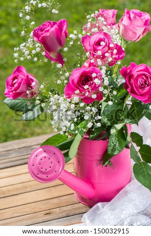 Beautiful pink roses in a pink watering can