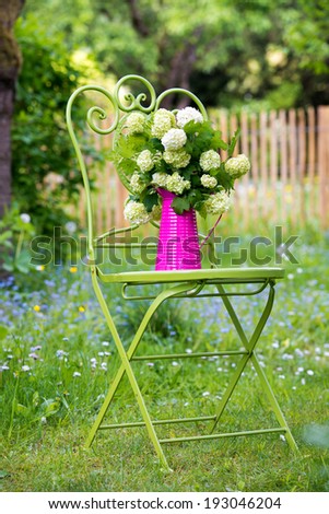 Garden chair with flowers in a romantic garden