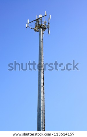 Telecommunications tower. Mobile phone base station in a blue sky background.