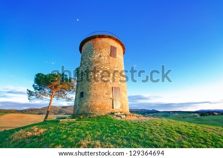 Tuscany, Maremma typical countryside sunset twilight landscape with hills, tree and rural tower.