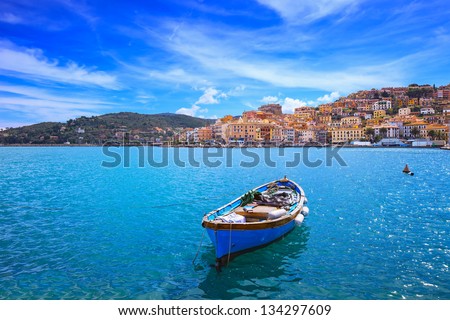 Wooden small old boat in Porto Santo Stefano seafront, italian travel destination. Monte Argentario, Tuscany, Italy.