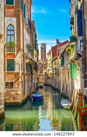 Venice cityscape, narrow water canal, campanile church on background and traditional buildings. Italy, Europe.