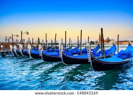 Venice, gondolas or gondole on a blue sunset twilight and San Giorgio Maggiore church landmark on background. Italy, Europe.