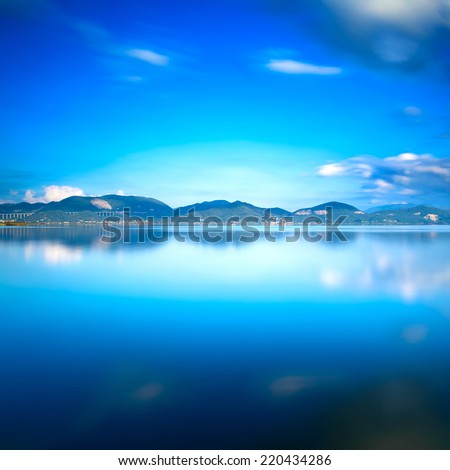 Blue lake sunset and sky reflection water. Long exposure, Versilia Massaciuccoli, Tuscany, Italy.
