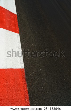 Texture of motor race asphalt and red white curb. Close up on Grand Prix street circuit