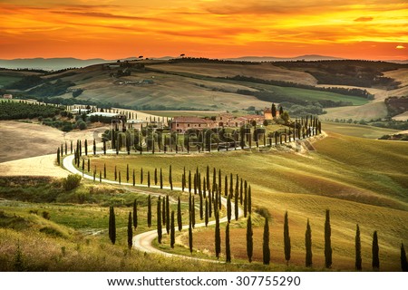 Tuscany, rural sunset landscape. Countryside farm, cypresses trees, green field, sun light and cloud. Italy, Europe.
