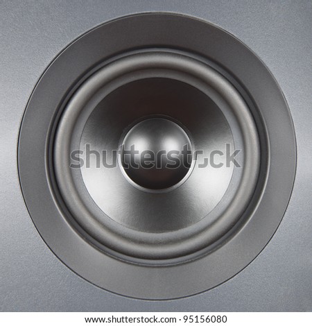 A silver speaker close up with symmetric light. Audio system equipment.