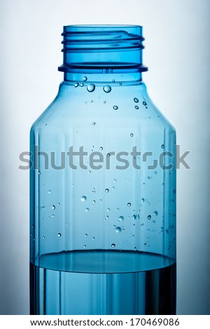 A water filled blue plastic bottle against light background