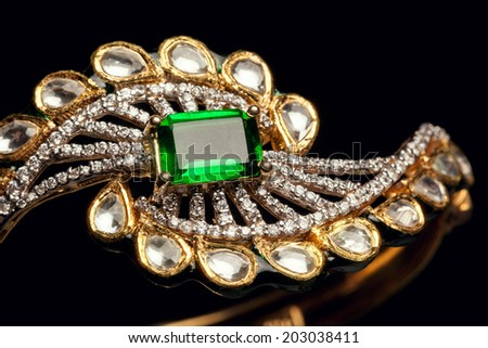 Designer diamond bracelet with many stones on reflective background.