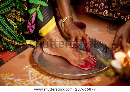 Indian bride doing marriage rituals doing colored  foot fingure their mandap puja