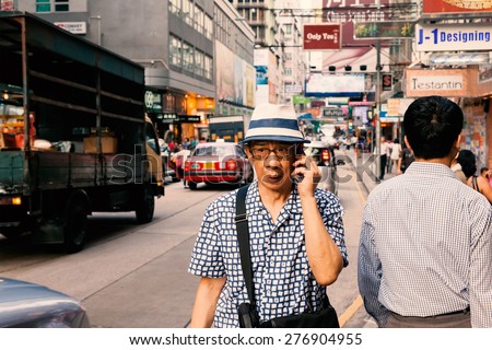 Man using cell phone and walking on the street, Kimberley Road,  Hongkong, China, 22 june, 2013