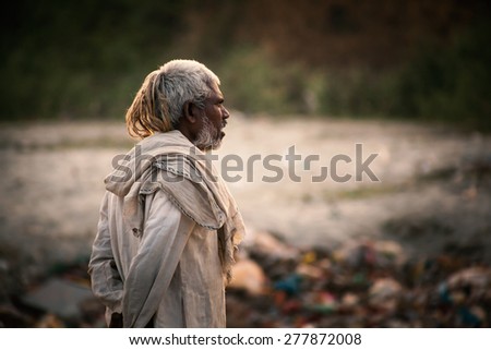 Portrait of poor old Indian man dressed in the old dirty cloths in evening. Kanpur, India, 23 November 2014.