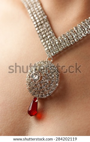 Close up of diamond necklace over female body skin