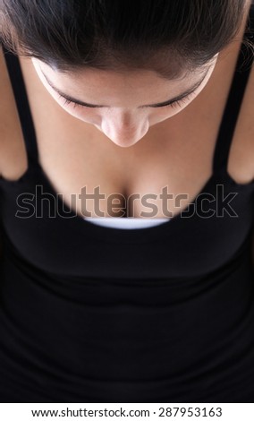 Close up of a sexy and beautiful Indian woman looking down in black dress
