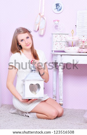 Young girl sitting on the floor with white candlestick in heart shape,vintage style