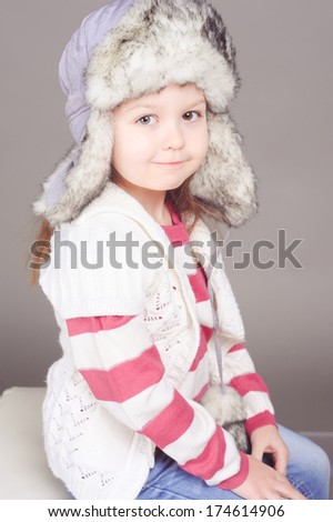 Sweet girl wearing winter clothes in studio