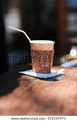 Paper cup with coffee on table outdoors