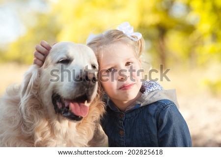 Smiling kid girl with dog outdoors