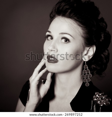 Brunette woman posing in room closeup. Black and white image. Young girl over black.