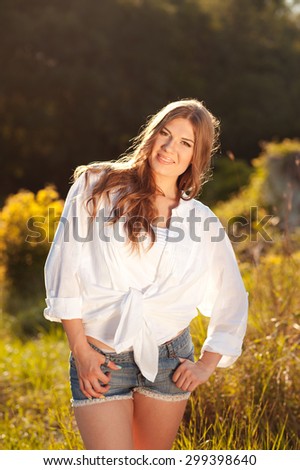 Smiling girl 20-24 year old posing outdoors. Wearing casual clothes. Summer time.