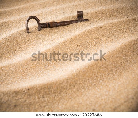 forgotten, unwanted, old, antique, key in a sand dune