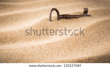 forgotten, unwanted, old, antique, key in a sand dune