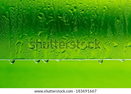 drops of water on glass with green background down in macro lens shot