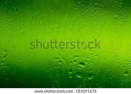 drops of water on glass with green background down in macro lens shot