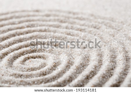Japanese zen garden meditation for concentration and relaxation. Sand circles in spiral for harmony and balance in pure simplicity. Macro lens shot.
