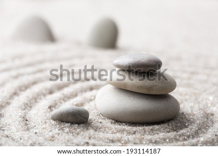 Japanese zen garden meditation stone for concentration and relaxation sand and rock for harmony and balance in pure simplicity - macro lens shot