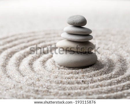 Japanese zen garden meditation for concentration and relaxation. Sand circles in spiral and rocks for harmony and balance in pure simplicity. Macro lens shot.