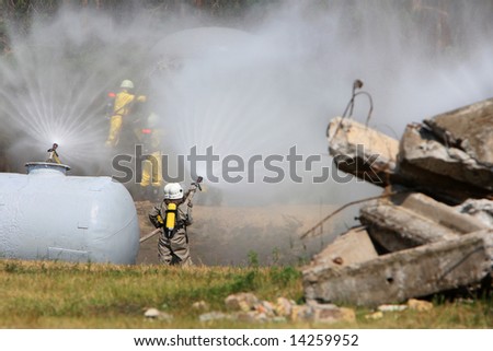 group of firefighters spraying water on a chemical accident