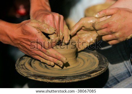 Training to potter\'s skill on a potter\'s wheel with damp clay. Close up.
