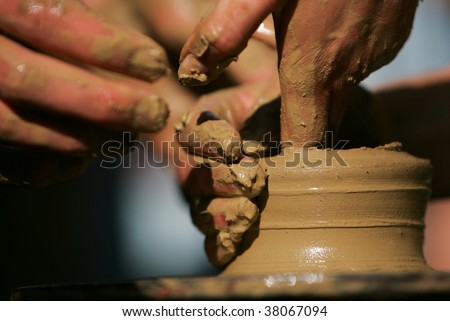 Training to potter\'s skill on a potter\'s wheel with damp clay. Close up.