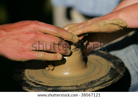 Training to potter's skill on a potter's wheel with damp clay. Close up.