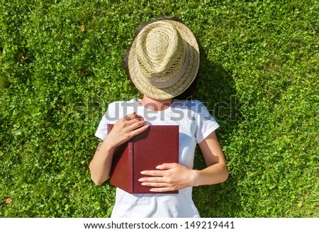 Girl sleep on the Field with book