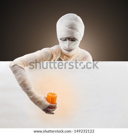 Halloween mummy with a candle invites on party. Space for text.
