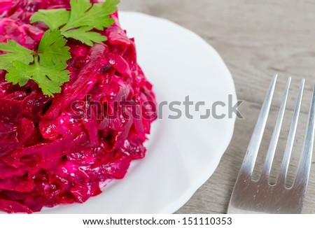 Beet salad with parsley on white plate, close-up
