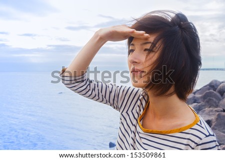 Young woman looks into the distance at sea